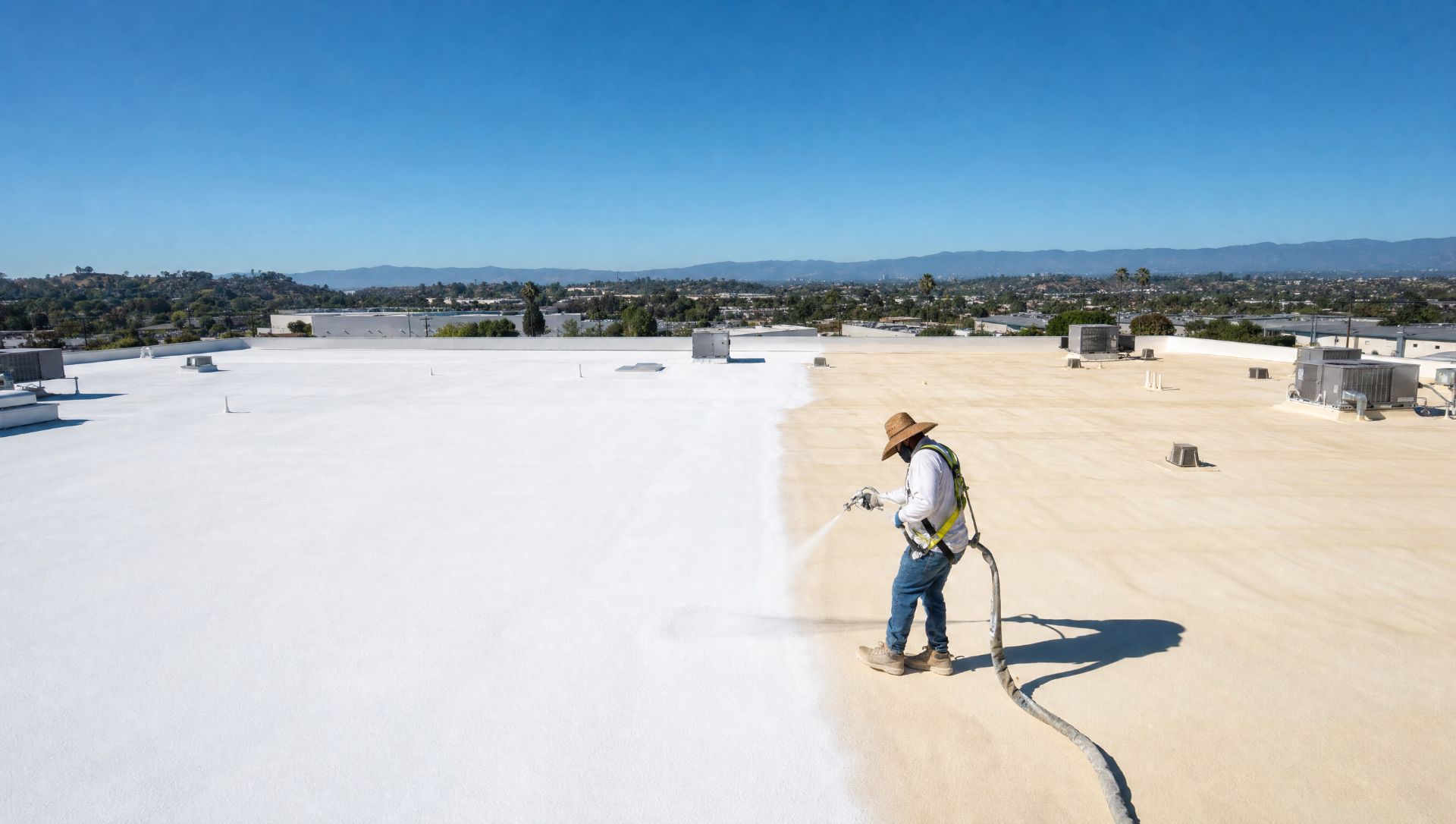 Contractor coating a spray foam commercial roof Contractor coating a spray foam commercial roof
